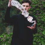 Iluzjonista Krzysztof Szostek podczas pokazu z kartami