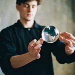 Iluzjonista Krzysztof Szostek podczas pokazu z kulą akrylową